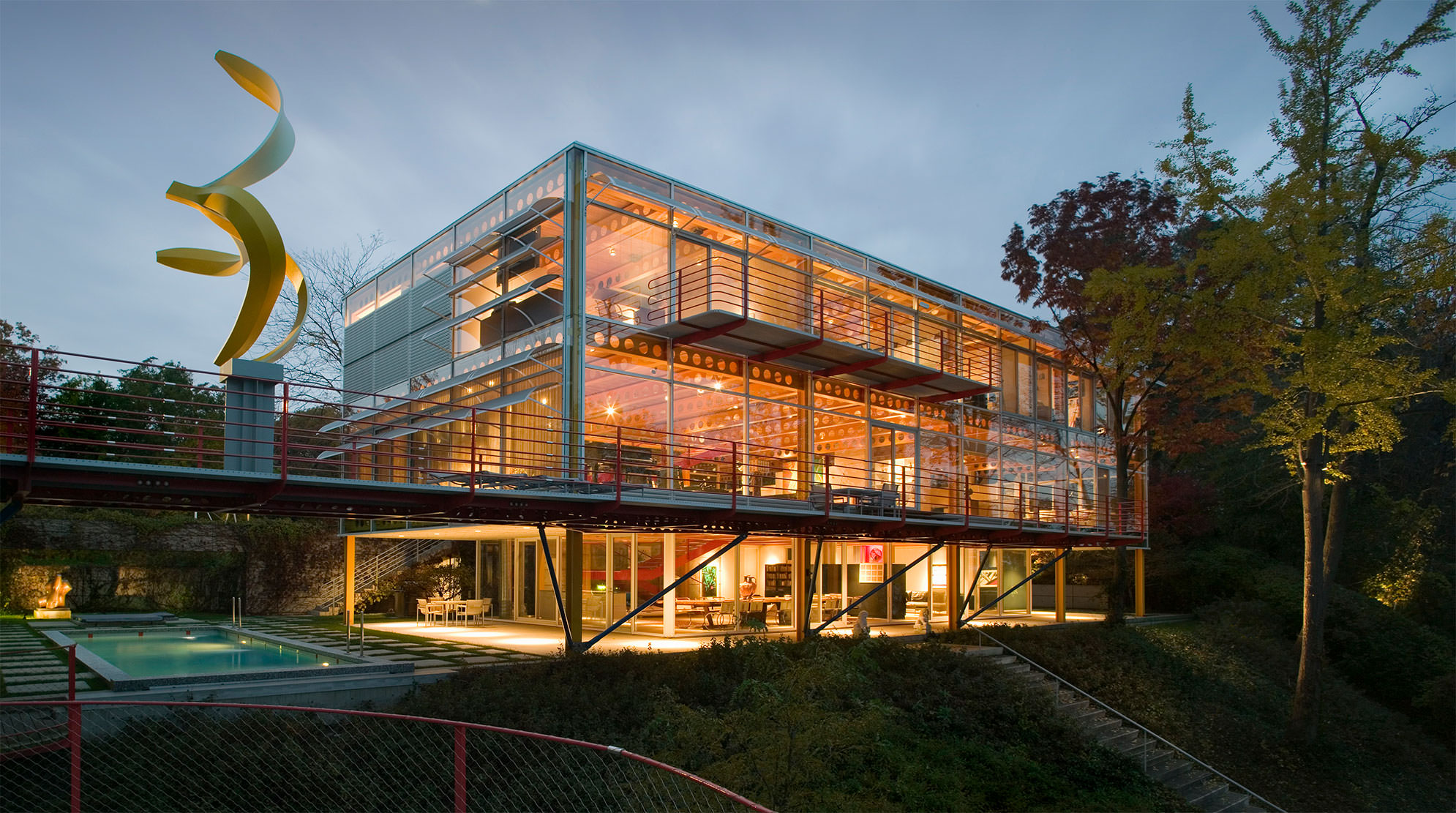 Exterior of Ravine Bluff at night, with the steel-and-glass home aglow with light.